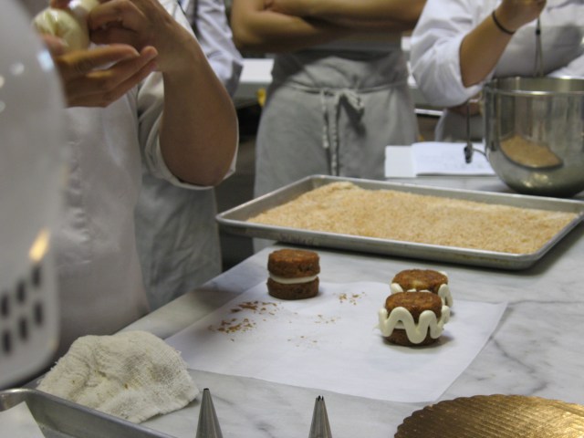 frosting the sides of the carrot cakes